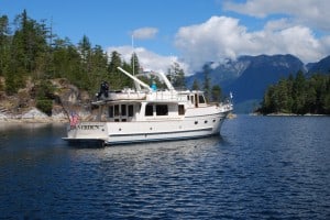 Shirley is at the Couverden helm, while Steve is getting the anchor ready –cruising around to find their preferred anchor location.